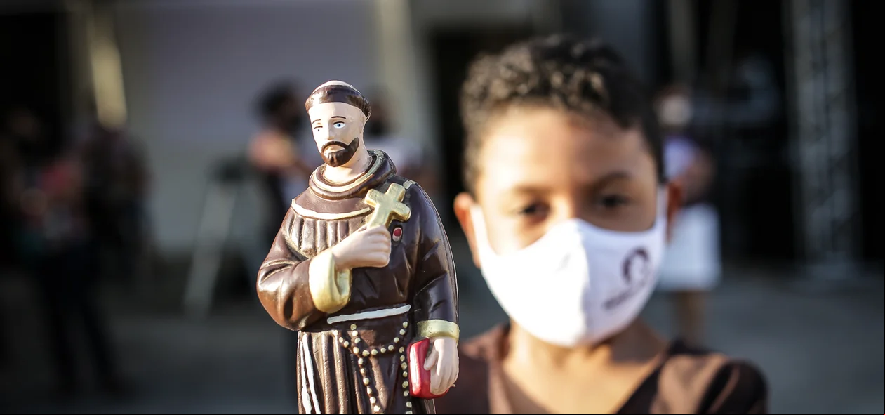 Menino mostrando a imagem de São Francisco