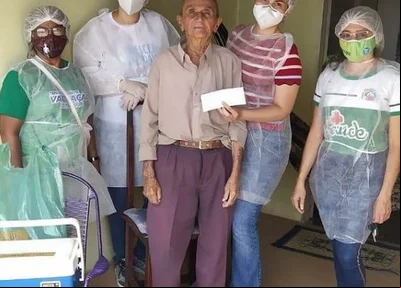 Idoso recebe a vacina contra a covid-19 em sua residência