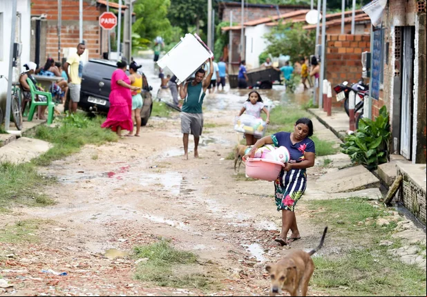 Famílias retiram seus pertences das casas alagadas devido a fortes chuvas em Teresina