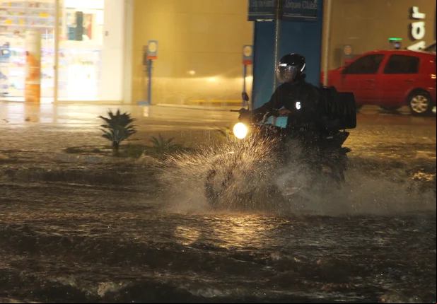 Motociclista enfrentando o trânsito na chuva