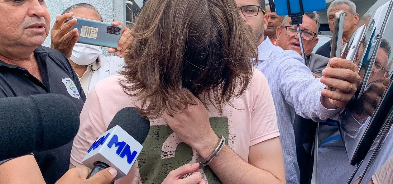 Marcos Vitor cobriu o rosto ao deixar a Central de Flagrantes