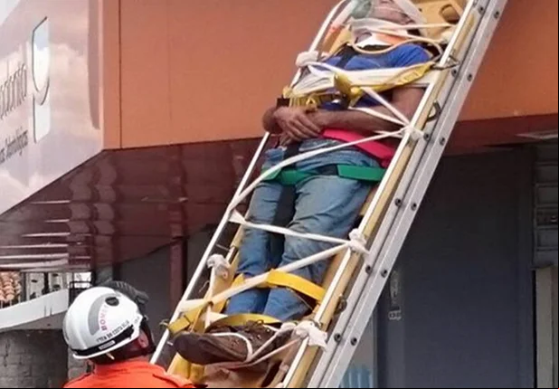 Homem sendo resgatado pelos bombeiros