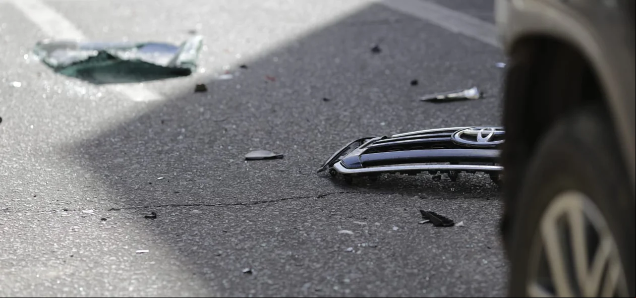 Pedaços do para-choque do carro ficaram no chão