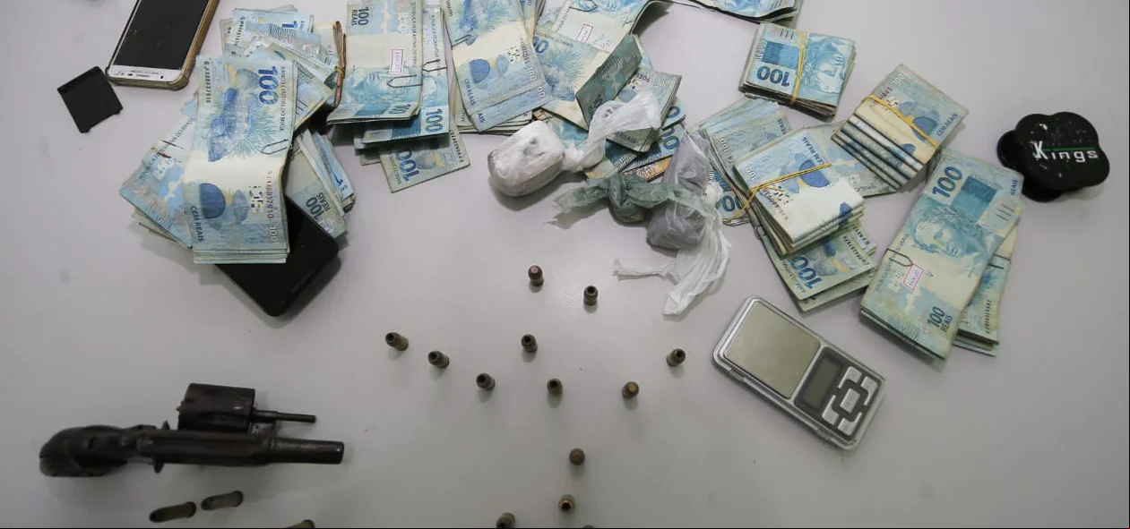 Dinheiro e arma apreendida pela polícia 