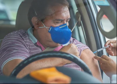 Idoso em vacinação no estilo drive-tru