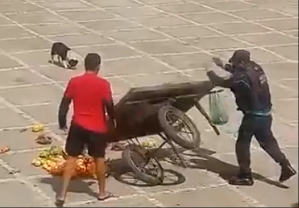 Policial virando carrinho de vendedor