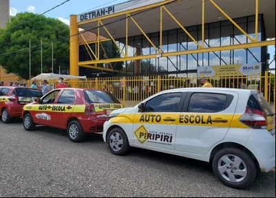 Carros de autoescolas estacionados na frente do Detran